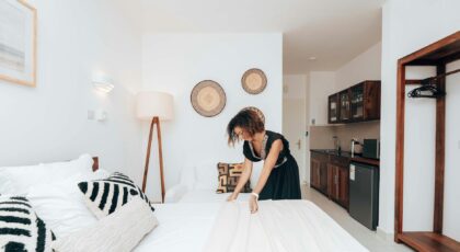 Elegant hotel suite in Zanzibar with modern interior and a woman arranging the bed.