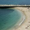 Relaxing beach day in Ancona, Italy with clear waters and sunbathers enjoying summer.