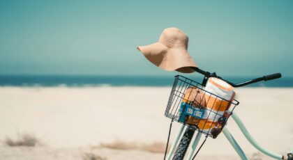 A vintage bicycle with a sun hat and towel at Coronado Beach, perfect summer vibes.