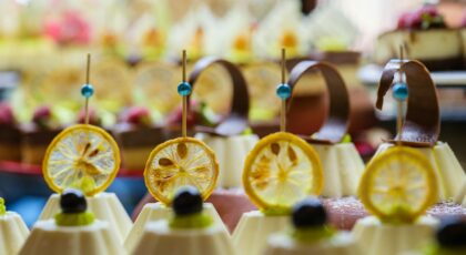 A close-up of beautifully presented desserts topped with dried lemon slices, showcasing exquisite catering.