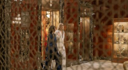 Luxurious hotel interior with two women elegantly dressed exiting an elevator in a stylish hall.