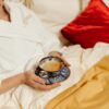 Relaxing morning in bed with a cup of coffee, wearing a bathrobe.