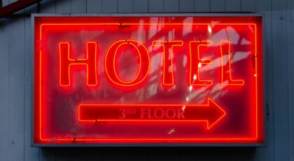 Close-up of a neon hotel sign indicating the 3rd floor, vibrant in red.