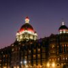 The iconic Taj Mahal Palace in Mumbai illuminated by twilight, showcasing its grand architecture.