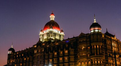 The iconic Taj Mahal Palace in Mumbai illuminated by twilight, showcasing its grand architecture.