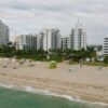 Aerial view of beachfront cityscape with tall buildings and sandy shore.