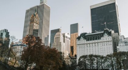 View of New York City's skyscrapers from Central Park with autumn foliage.