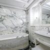 Elegant bathroom with marble walls and modern fixtures creating a luxurious at-home experience.
