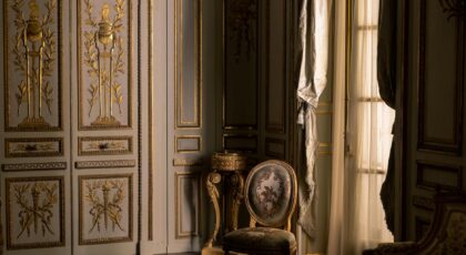 Luxurious interior featuring ornate gold design and classic furniture in a regal setting.