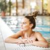 A serene moment as a woman relaxes in a poolside setting at a luxurious resort, enjoying the summer vibes.