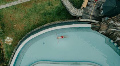Aerial shot of a man floating peacefully in a resort pool surrounded by lush greenery, Sri Lanka.