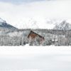 Stunning Vysoké Tatry winter landscape featuring a snow-covered hotel amidst majestic mountains.