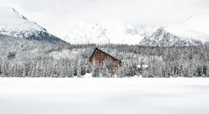 Stunning Vysoké Tatry winter landscape featuring a snow-covered hotel amidst majestic mountains.